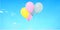 Flying coloured balloon on blurred sky background