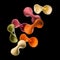 Flying colourful farfalle pasta isolated on black background