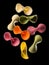 Flying colourful farfalle pasta isolated on black background