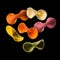 Flying colourful farfalle pasta isolated on black background