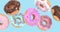 flying doughnuts - mix of multicolored sweet donuts with sprinkles on blue background isolated. 3d animation