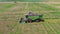 Flying drone along cereal field and harvester collecting grains