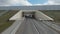 Flying drone on country road with tunnel. Shot. Beautiful panorama with country highway and drone following car. Top