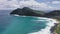 Flying drone over the ocean. View of makapuu lighthouse. Waves of Pacific Ocean wash Rocky shore. Magnificent mountains