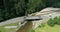 Flying a drone over a road bridge in a mountainous forest area.