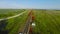 Flying on drone by rail. Shot. Top view of fast train ride. Beautiful flight over empty railway in field with red