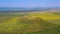 Flying drone in summer rural landscape, green hill and colored culture fields