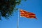 Flying flag of Catalonia against blue sky. Catalonia flag waving against clear blue sky.