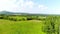 Flying forward above the grass revealing the landscape around in the country