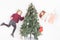 Flying girls decorating Christmas tree, dressed in sweater