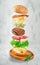 Flying hamburger on gray concrete background. Fast food concept