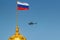 Flying helicopter in blue sky against national flag of Russian Federation on the dome of Grand Kremlin Palace in sunny morning