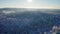 Flying high above epic snow covered forest in cold winter landscape