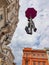 Flying high, statue of man hanging from umbrella high above street