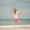 Flying jumping beach girl at blue sea shore