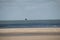 Flying kite surfer at deserted beach