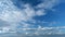 Flying moving white clouds in a blue sky. Blue sky background with many layers tiny clouds. Timelapse.