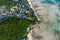 Flying over a busy paradise island harbor on a beautiful summer day. Remote harbor village is swarmed by tourist boats going on