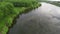 Flying over the calm lake and green trees