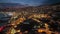 Flying over coastline in evening Funchal, blue sunset sky and city lights. Aerial view of night Funchal city, Madeira