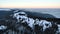 Flying over communications tower, mountain snow covered winter landscape.