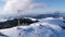 Flying over communications tower, mountain snow covered winter landscape.