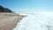 flying over frozen sea bay bay on a sunny day blue sky coastline and rocks and green trees