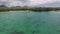 Flying over the Indian ocean in Mauritius. Albion area with yacht and beach. People walking on sand.