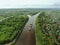 Flying over a large cargo ship with open holds sailing down a calm river surrounded by forest. Carriage of goods by river.