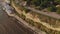 Flying over the lighthouse on a cliff of the coast near the sea. Aerial shot