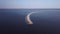 Flying over the pier with an abandoned lighthouse with flocks of seagulls on a sunny day