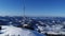 Flying over radio communications tower, mountain snow covered winter landscape.