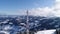 Flying over radio communications tower, mountain snow covered winter landscape.