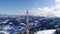 Flying over radio communications tower, mountain snow covered winter landscape.