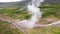 Flying over Strokkur geysir during eruption of water, Iceland, aerial drone view