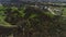 Flying over stunning cityscape and green summer landscape. Shot. Aerial view of curving wide and narrow roads and paths