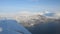 Flying over the Tromsoe city island and the mainland of Tromsdalen in late winter sunshine, aerial overview video