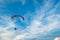 A flying paramotor on a vibrant sky with cloud.