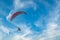 A flying paramotor on a vibrant sky with cloud.