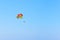 Flying paratrooper with full color parachute, isolated on a blue sky near Rhodes island, Greece