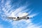 Flying passengers aircraft fly climb on a background of blue sky and cirrus clouds.