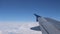 Flying on the plane over the clouds surface, view from the window on wing.