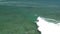 Flying POV, surfer riding wave off the coast of Philippines, in aquamarine water, slow motion _