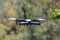 Flying quadrocopter on a background of green foliage, close-up