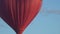 Flying red hot air balloon in the shape of a heart flying
