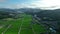 Flying straight over river of rice fields in mountain valley with morning light