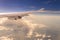 Flying into sunset sky and sea of clouds and Wing of airplane wi