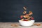 Flying tiny pancake cereal - trendy quarantine food. Mini pancakes and fresh raspberries in motion falling in white bowl on black