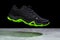 Flying touristic waterproof black and green man shoe from side on marble background