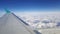 Flying and traveling abroad, view from airplane window on the wing on cloudy blue sky aboard morning winter time, journey